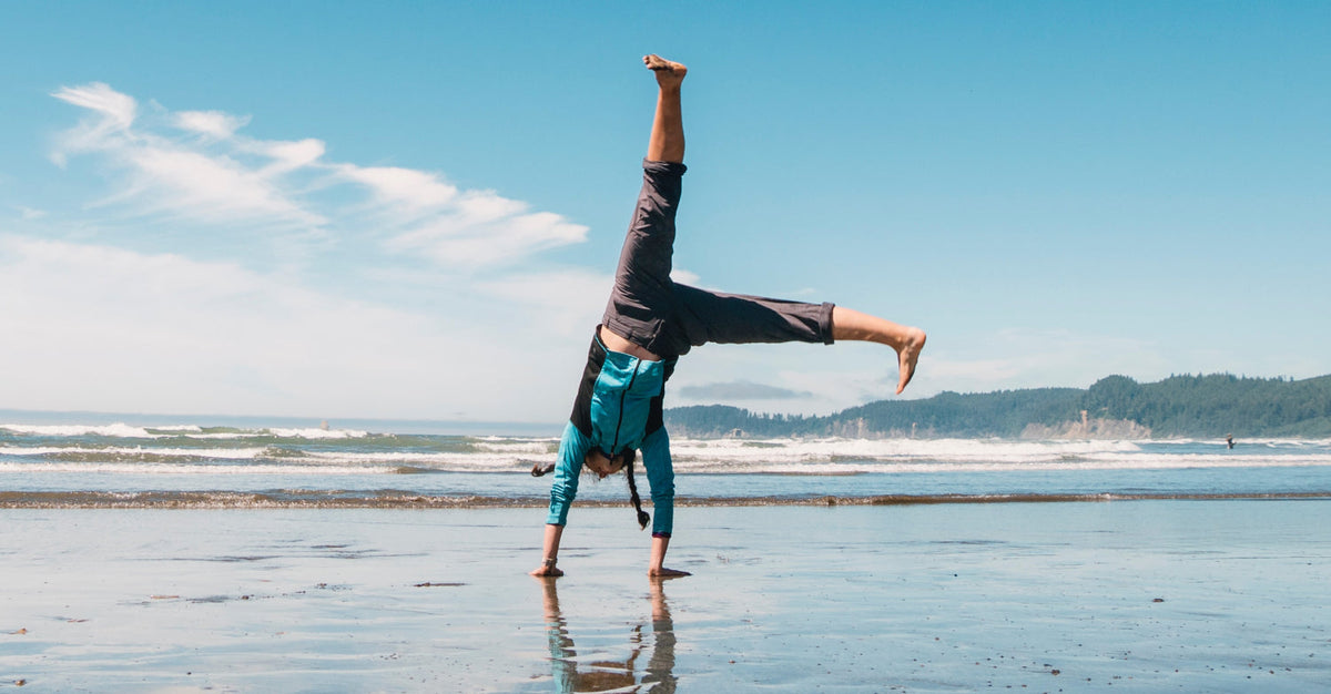 Woman doing cartwheel on beach