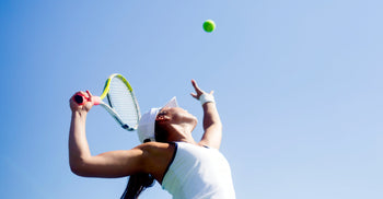 Athlete serving a tennis ball outdoors, illustrating how regular exercise supports healthy aging.