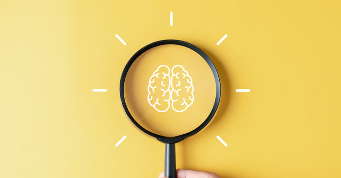 Yellow background with microscope revealing white brain illustration