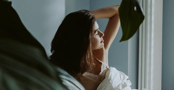 Woman stretching, waking up well rested due to supported circadian rhythm.