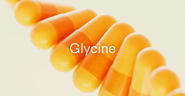 Row of orange and yellow glycine supplement capsules, highlighting the amino acid's role in health and longevity.