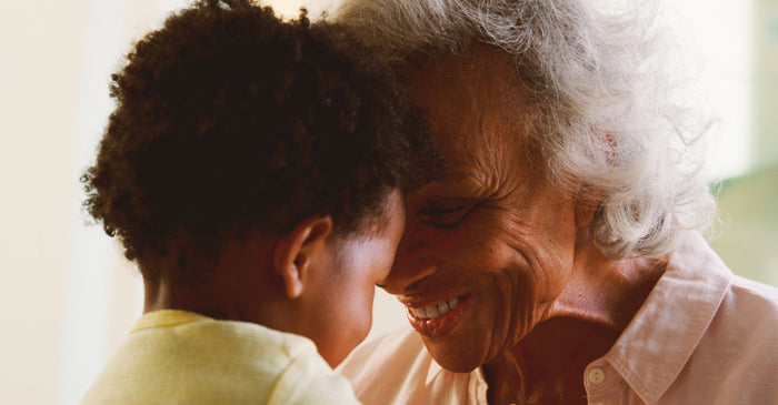 Grandmother, and young child smiling together.