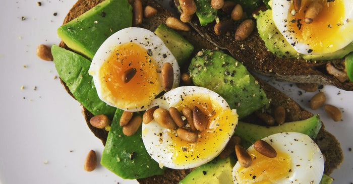 A close up of a salad featuring a hard-boiled egg cut in half. 