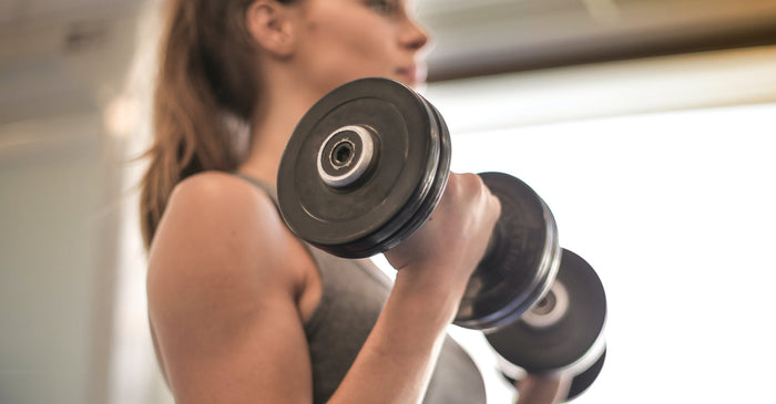 Close-up of a woman lifting a dumbbell during a bicep curl exercise