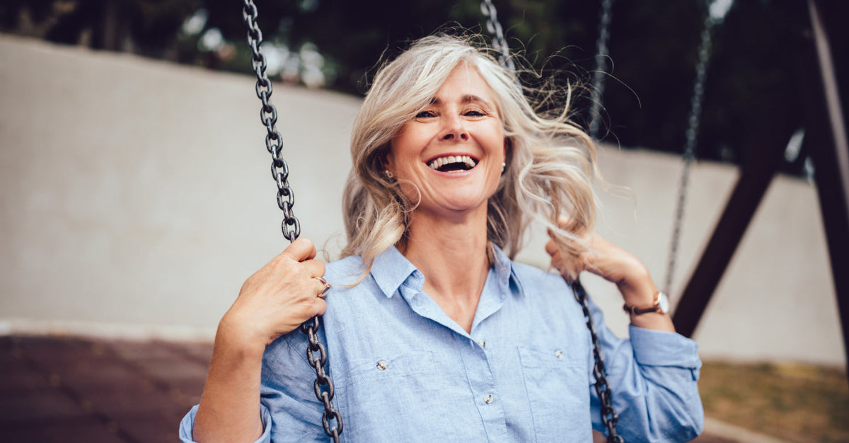 Happy older woman with gray hair on a swing