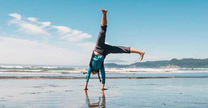 Woman doing cartwheel on beach