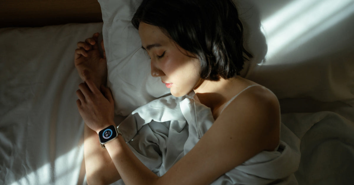 A person sleeping while wearing a smartwatch that tracks sleep data such as heart rate and sleep stages.