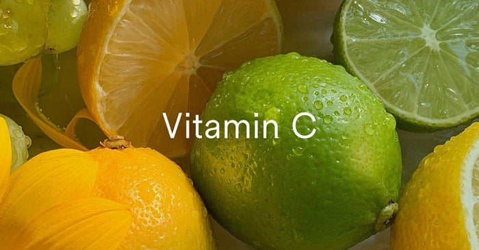 A close-up, top-down view of cut lemons and limes with water droplets on them. The words 