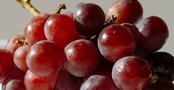 Close-up of fresh red grapes, the natural source of trans-resveratrol, a polyphenol linked to heart and cellular health.